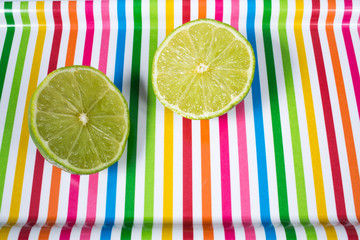 A lime sliced in half  on multicolored tray