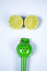 Lemon squeezer and a lime sliced in half isolated on white background