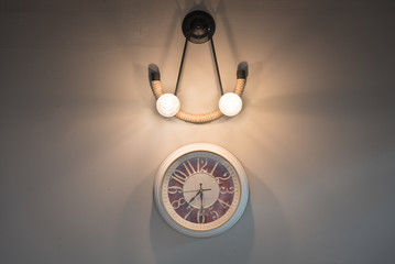 Hanging clock and hanging lamp on the wall.