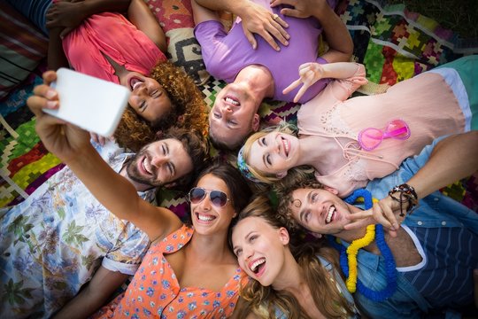 Group of friends lying in a circle and taking a selfie