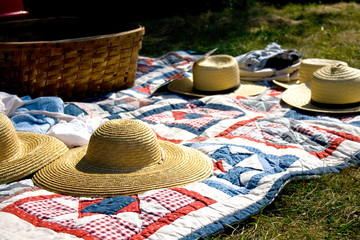 Straw Hats and Picnic Basket on Quilt