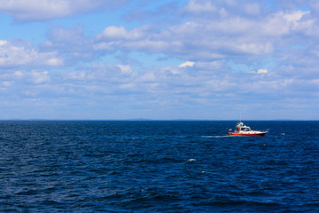 Small Red and White Boat on Blue Ocean Sunny Day