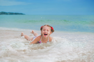 Adorable little girl at beach during summer vacation