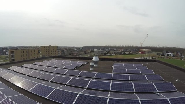 Aerial flight low altitude bird view over sustainable roof of modern building with solar panels designed to absorb the sun's rays as source of energy for generating electricity or heating 4k quality