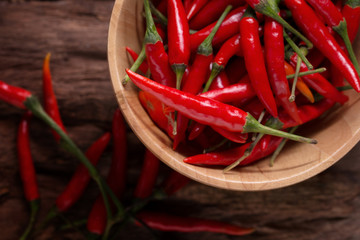 Red hot chili peppers in Wooden bowl on wooden background. Spicy chilli peppers