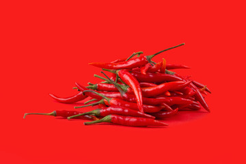 Red hot chili peppers isolated on red background. Spicy chilli peppers
