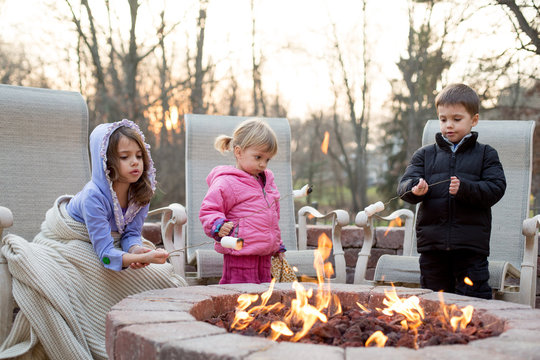 Three children around an open fire