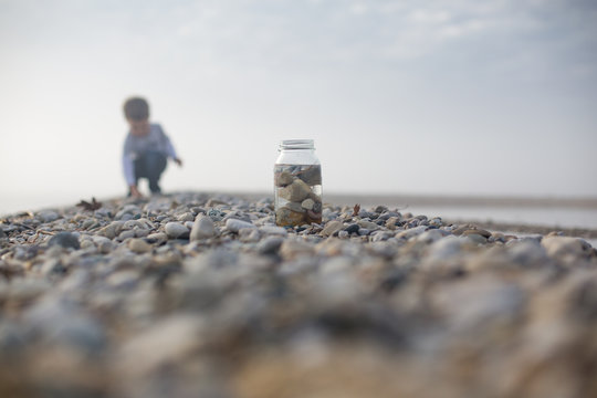 Boy collecting pebbles on beach