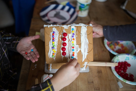 Children decorating a gingerbread house
