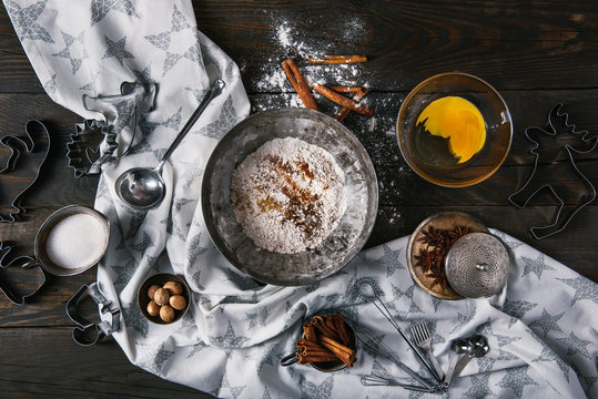 Ingredients for making ginger cookies over scorched wooden background