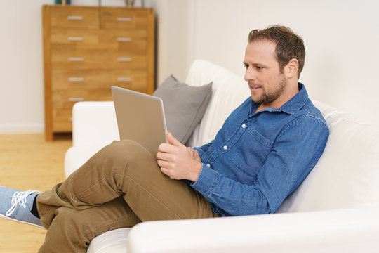 mann liest zuhause am laptop