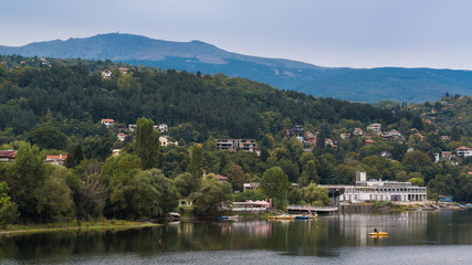 Fototapeta na wymiar Houses on the hillside in front of the lake Pancharevo. Sofia, Bulgaria