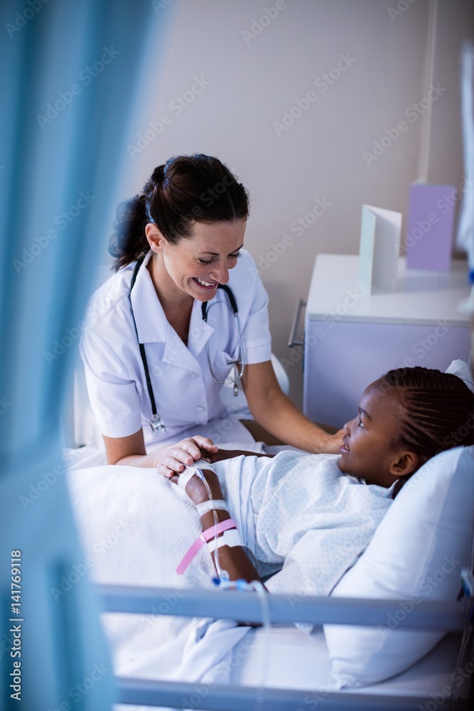 Wall mural Female doctor consoling patient during visit in ward