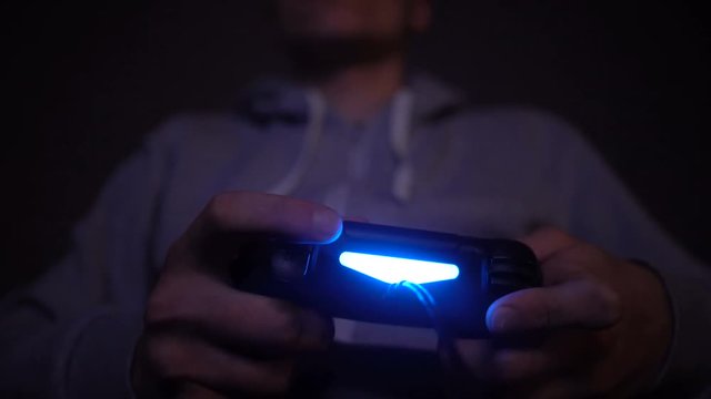 Close-up man's hand with controller, game pad. Man play at night