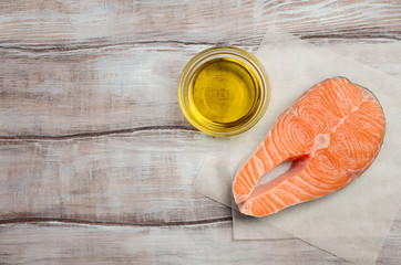 Fresh raw salmon steak with olive oil, ready for cooking. Healthy diet concept. Top view, copy...