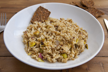 rice with vegetables dish in a wooden background with crackers and lemonade