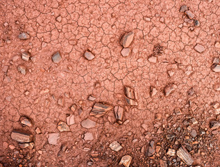 texture with stones and cracks on red ground of iron mineral