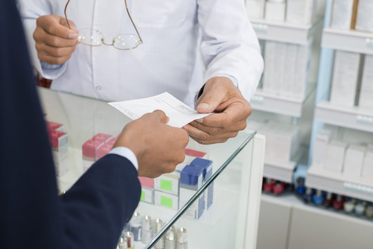 Cropped Image Of Businesswoman Showing Prescription To Chemist