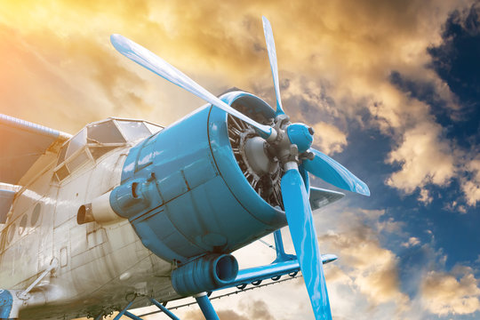 Fototapeta plane with propeller on beautiful bright sunset sky background
