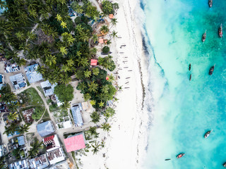 beautiful turquoise ocean meets african island with houses and palms on Zanzibar, aerial photo, top...