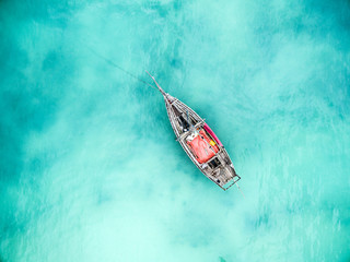 lonely fishing boat in clean turquoise ocean, aerial photo, top view