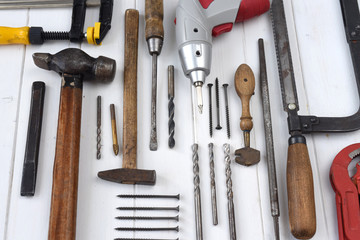 different carpenters and mechanics tools on a white wooden table