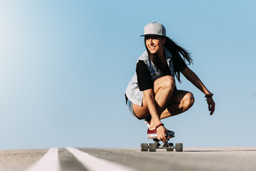 Beautiful skater woman riding on her longboard. - obrazy, fototapety, plakaty
