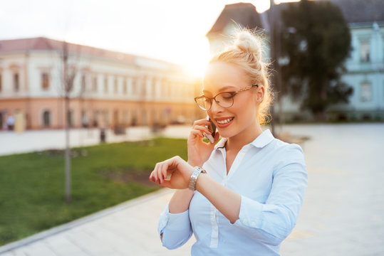 Girl Checking Time While Talking On Mobile Phone