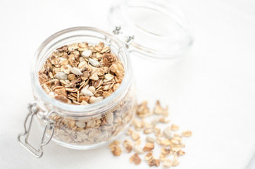 Healthy breakfast of homemade granola cereal with nuts and fruit, honey with drizzlier background. Morning food, Diet, Detox, Clean Eating, Vegetarian concept.