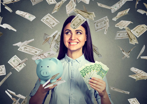 Woman with piggy bank and euro cash under dollar money rain