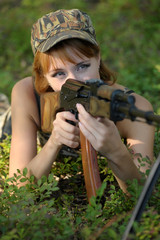 Beautiful girl in the woods with a machine gun Kalashnikov