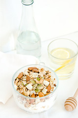 Good morning with homemade granola cereal, nuts, bottle, lemon water, drizzlier for breakfast. Healthy food, Diet, Detox, Clean Eating or Vegetarian.