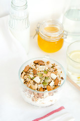 Good morning with homemade granola cereal, nuts, honey, milk bottle, lemon water, for breakfast on white background. Healthy food, Diet, Detox, Clean Eating or Vegetarian.