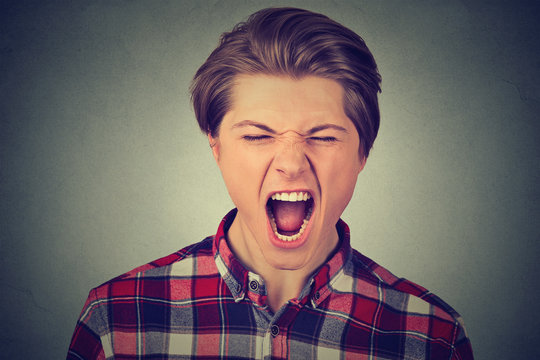 Closeup portrait of a young angry man screaming