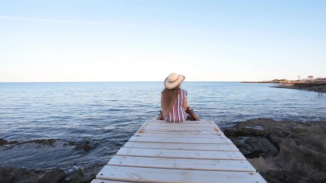 Young woman sitting on pier