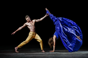 The dancing couple in the darkness, make dance support in the dancing movement. Staging and...