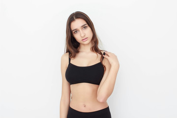 Fototapeta premium Beautiful girl in black top on white background shows emotion