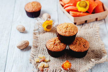 hearty and healthy breakfast, lunch, pastries, carrot cupcakes with raisins, candied fruits, nuts and green tea on a wooden background 