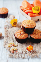 hearty and healthy breakfast, lunch, pastries, carrot cupcakes with raisins, candied fruits, nuts and green tea on a wooden background 