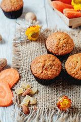 hearty and healthy breakfast, lunch, pastries, carrot cupcakes with raisins, candied fruits, nuts and green tea on a wooden background 