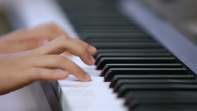 Little girl playing on electronic piano