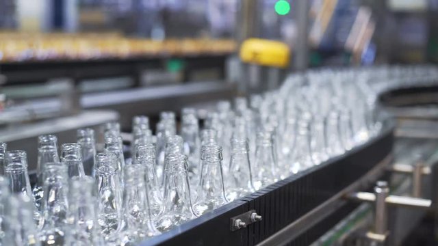 Bottles factory interior with a lot of machines. Bottle manufacturing technology in industrial factory. Close-up