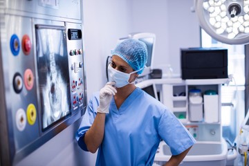Female surgeon reading x-ray