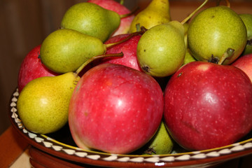 Ripe apples and pears in a clay dish