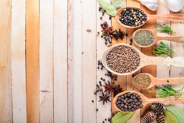A set of fragrant spices. A mixture of black and red pepper, coriander, paprika. On Wooden background. Top view. Free space.