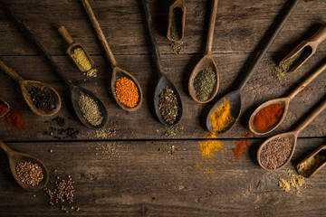 Various colorful spices on wooden table. Place for typography and logo