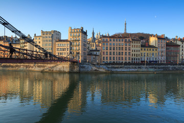 Pedestrian walking over Passerelle Saint-Vincent, crossing the Saone river, at dawn. Lyon, France.