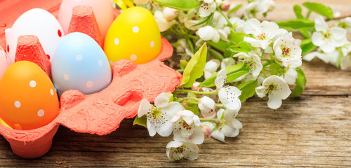 Easter eggs and flowers on wooden background