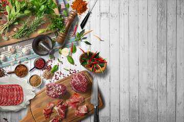 Overhead view of colorful roast vegetables, savory sauces and salt served with grilled t-bone steak...