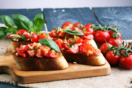 Tasty savory tomato Italian appetizers, or bruschetta, on slices of toasted baguette garnished with basil
